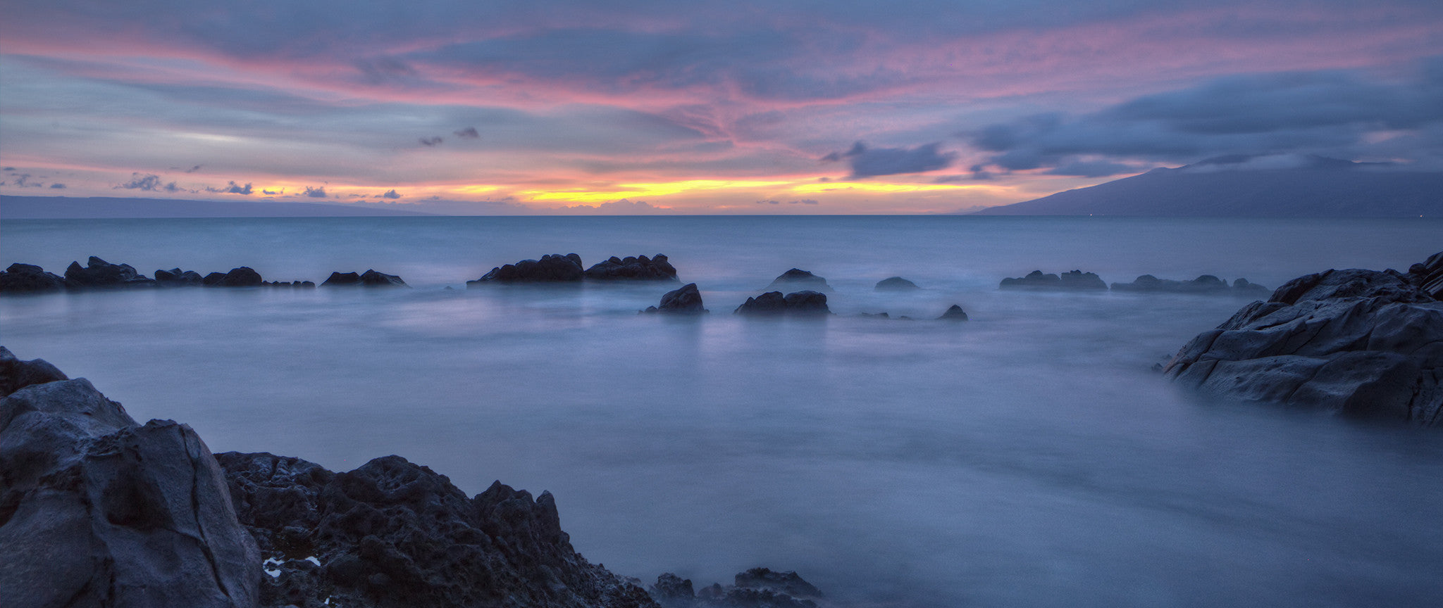 A dark and beautiful sunset shot taken on Maui. The slow shutter speed enables the ocean in the forground to look almost like smoke.