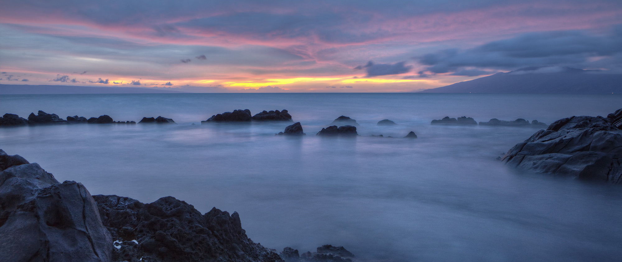 A dark and beautiful sunset shot taken on Maui. The slow shutter speed enables the ocean in the forground to look almost like smoke.